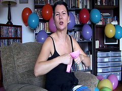 Flirtatious brunette solo model enjoys blowing balloons