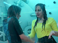 Girls having fun kissing and dancing in a shower on a club stage