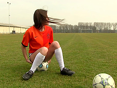 Soccer chick sits on a ball on the field and masturbates