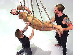 Tied up guy with a ball gag tortured and pleasured by his gay friends