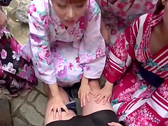 Horny Asian girls take turns at playing with a cock outdoors