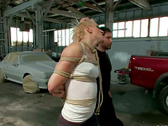 Tied up blondie gets fucked in a car service in public