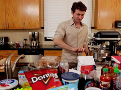 Video of two handsome guys preparing the lunch in a kitchen